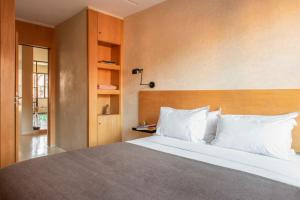 a bedroom with a large bed with white pillows at Appartements Brummell Marrakech in Marrakech