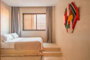 a small bedroom with a bed and a window at Appartements Brummell Marrakech in Marrakech