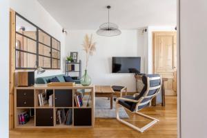 a living room with a table and a chair at Hamac Suites - Le Renan - 4 people in Lyon