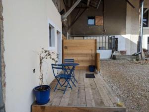 einen Tisch und einen Stuhl auf einer Holzterrasse in der Unterkunft Logement - Studio indépendant à Pérouges in Pérouges