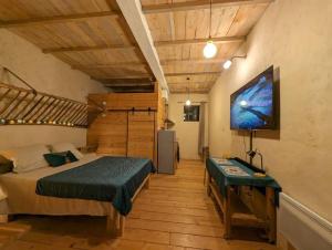 Un dormitorio con una cama y un televisor de pantalla plana. en Logement - Studio indépendant à Pérouges, en Pérouges