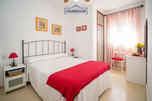 a bedroom with a large bed with a red blanket at Apartamento mi Gitana in La Jara