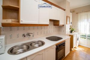 a kitchen with white cabinets and a sink at Apartamento mi Gitana in La Jara
