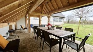 eine Terrasse mit einem Holztisch und Stühlen in der Unterkunft Le 225 villa 8 personnes in Saint-Valery-sur-Somme