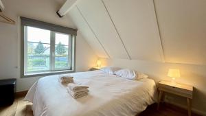 a bedroom with a white bed with towels on it at Le 225 villa 8 personnes in Saint-Valéry-sur-Somme