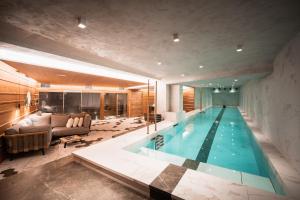 a swimming pool in a house with a living room at Hôtel LA MOURRA in Val dʼIsère