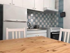 a kitchen with a wooden table and white cabinets at La Palma “Villa Nunzia” in Serrara Fontana