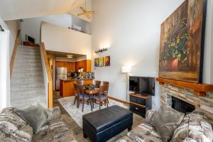 ein Wohnzimmer mit einem Sofa und einem Kamin in der Unterkunft Bright 2 bedroom and loft suite in the Wildwood Lodge in Whistler