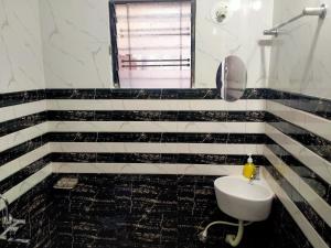 Baño en blanco y negro con lavabo y espejo en KIYAN VILLA, en Daman