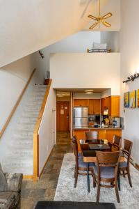 ein Wohnzimmer mit einem Esstisch und einer Treppe in der Unterkunft Bright 2 bedroom and loft suite in the Wildwood Lodge in Whistler