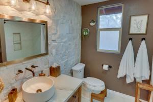 a bathroom with a sink and a toilet and a mirror at Cozy Wrightwood Cabin Family and Pet Friendly! in Wrightwood