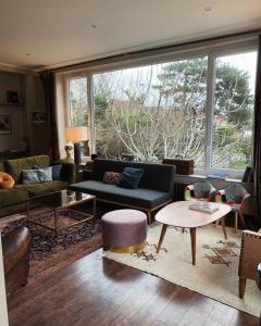 sala de estar con muebles y ventana grande en Chez-Marion, en Merville-Franceville-Plage