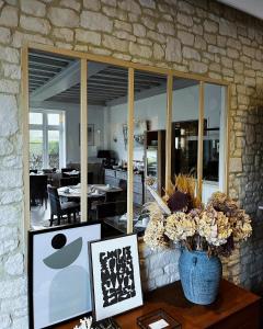 una sala de estar con una mesa con un jarrón de flores en Chez-Marion, en Merville-Franceville-Plage