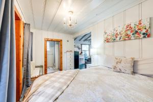 a bedroom with a large bed and a chandelier at Serene Bass Lake Cabin Near Shopping and Dining! in Bass Lake