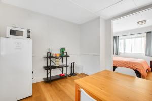 a white room with a bed and a refrigerator at Mount Ellinor, Room 11 at Mount Walker Inn in Quilcene