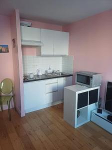 a small kitchen with white cabinets and a microwave at Au cœur du 5ème de Paris in Paris