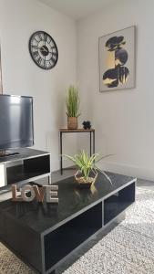 a black coffee table in a living room with a clock at Premium CITY APARTMENT near Harry Potter Studio and Luton Airport in Hemel Hempstead