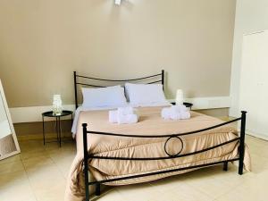 Tre Balconi - Casa Vacanza Salento في Carmiano: غرفة نوم عليها سرير وفوط