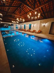 a swimming pool with blue water in a building at Hotel Pontal de Tiradentes in Tiradentes