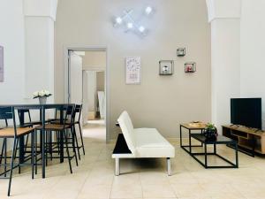 a living room with a table and chairs and a television at Tre Balconi - Casa Vacanza Salento in Carmiano