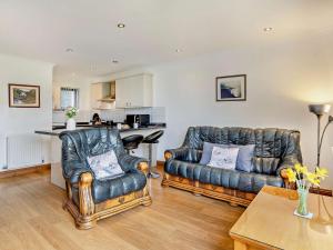 a living room with two leather couches and a kitchen at 2 bed in Gower 40480 in Dunvant