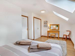 een witte slaapkamer met een bed en een bureau bij 2 bed in Gower 40480 in Dunvant