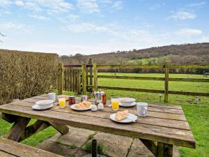 a wooden picnic table with food and drinks on it at 2 bed in Gower 40480 in Dunvant