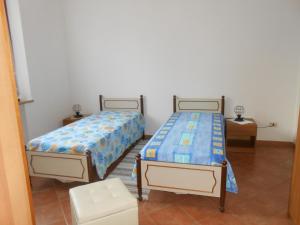 two beds in a room with two tables at Orto degli Ulivi in Sinalunga