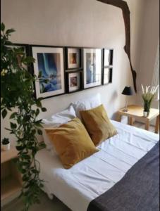 ein Bett mit weißer Bettwäsche und Kissen in einem Schlafzimmer in der Unterkunft Suites Rive Gauche - DUPLEX CHARME Fontainebleau in Fontainebleau