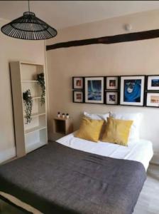 ein Schlafzimmer mit einem großen Bett mit gelben Kissen in der Unterkunft Suites Rive Gauche - DUPLEX CHARME Fontainebleau in Fontainebleau