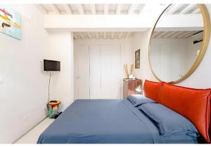 um quarto com uma cama azul e um espelho em Luxury Tower House in heart of Pisa Standard em Pisa
