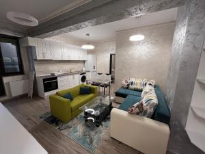 a living room with two couches and a kitchen at Apartments Lux Palas in Iaşi