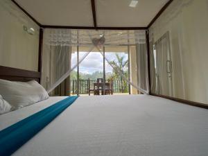 a bedroom with a large bed and a balcony at Rawana Rock Road Homestay in Ella