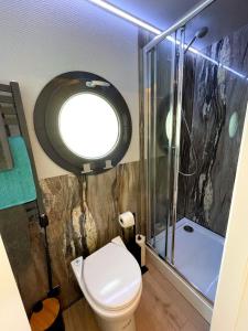 a bathroom with a toilet and a shower with a window at Yarmouth Waterlodge Floating Apartment 1 in Yarmouth