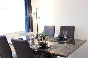 a dining room table with chairs and a table with wine glasses at Stunning 3 bedrooms Entire flat in Harlow, Essex in Harlow