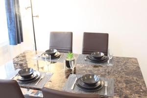 a dining room table with black plates and chairs at Stunning 3 bedrooms Entire flat in Harlow, Essex in Harlow