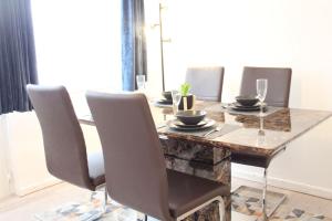 a dining room table with four chairs and a wooden table at Stunning 3 bedrooms Entire flat in Harlow, Essex in Harlow