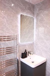 uma casa de banho com um lavatório e um espelho em Stunning 3 bedrooms flat at Orchard House em Harlow