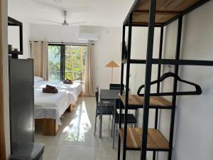 Schlafzimmer mit einem Bett, einem Schreibtisch und einer Leiter in der Unterkunft La Jungla in Carrillo