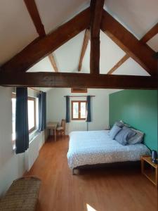 ein Schlafzimmer mit einem Bett in einem Zimmer mit Holzböden in der Unterkunft Holiday home at the edge of La Seine near Giverny in Moisson