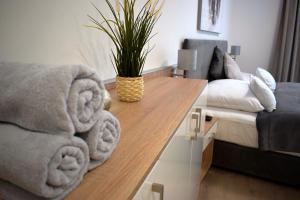 a living room with a couch and a table with towels at Spa Residence Carbona 101, 307 Apartman in Hévíz