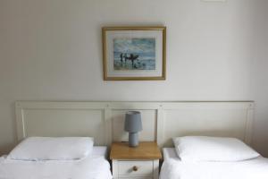 2 camas en una habitación con una foto en la pared en Leitrim Quay - Riverside Cottage 3, en Leitrim