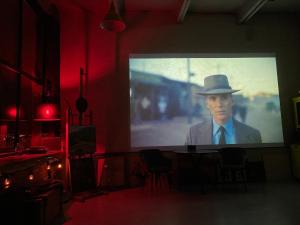 a large screen with a man in a hat on a stage at Лофт студия с панорамной террасой in Mykolaiv