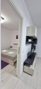 a bedroom with a bed and a desk in a room at MELISSA APARTAMENT in Constanţa