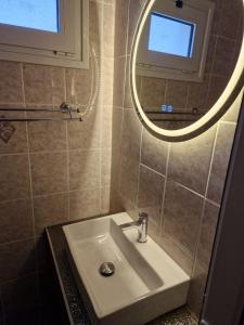 een badkamer met een wastafel en een spiegel bij Pension Delfini in Asprovalta