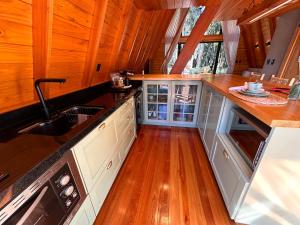 a kitchen with wooden floors and a sink and counters at Cabanas Gariba in Encantado
