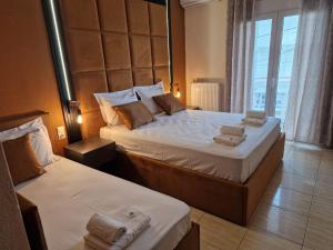 アスプロヴァルタにあるPension Delfiniのベッド2台と大きな窓が備わるホテルルームです。