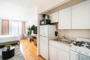 uma cozinha com um frigorífico branco e um lavatório em 338-3B union square Newly Reno Sleeps 3 em Nova York