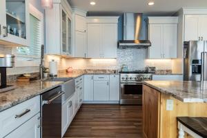 a kitchen with white cabinets and wooden floors at Snowmobile South Manistique Lake Lakeside Luxury in Curtis