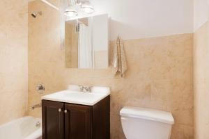 uma casa de banho com um lavatório, um WC e um espelho. em 338-3B union square Newly Reno Sleeps 3 em Nova York